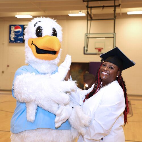 woman in grad cap with mascot