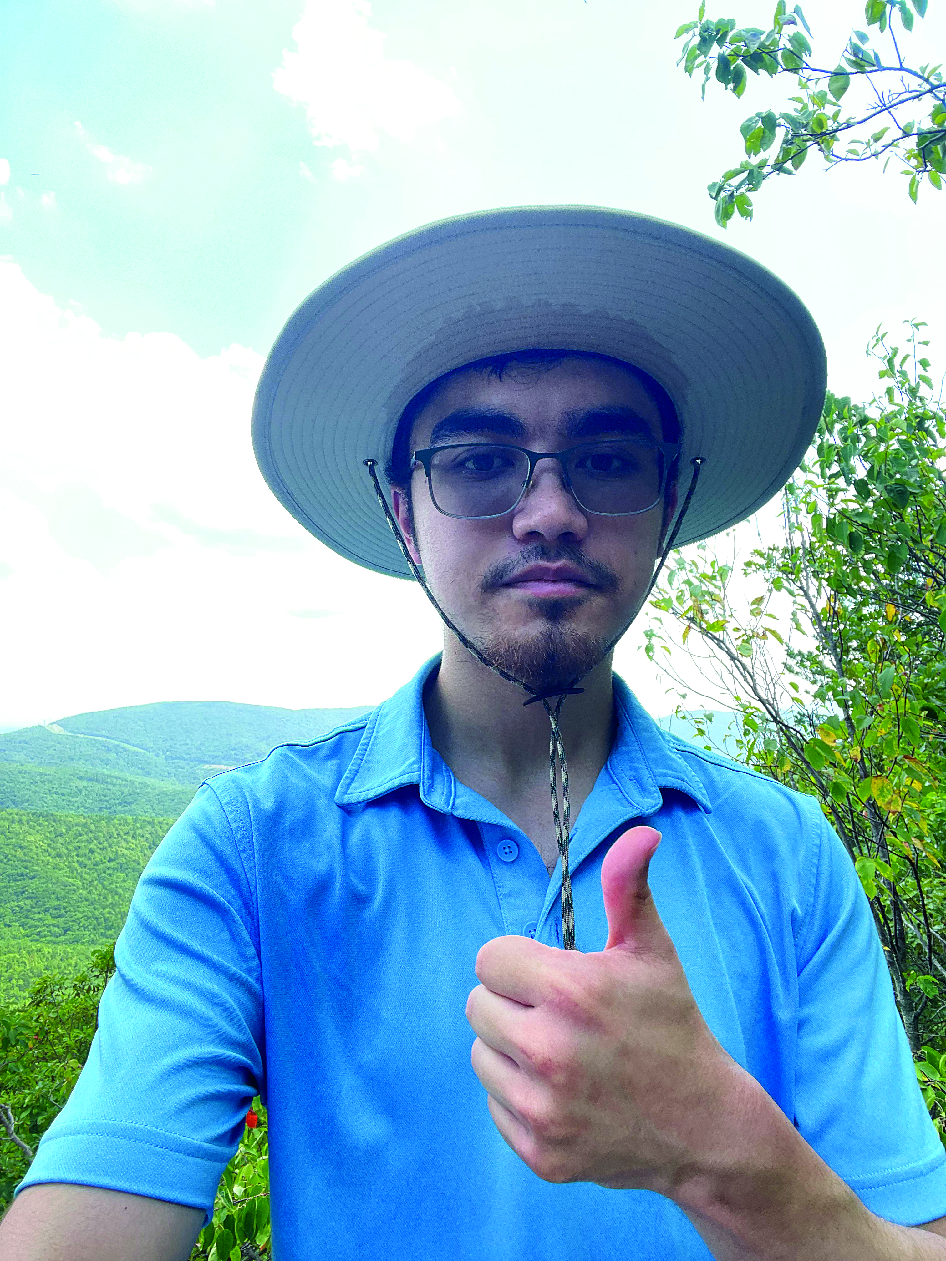 photo of young man wearing hat and showing thumbs up